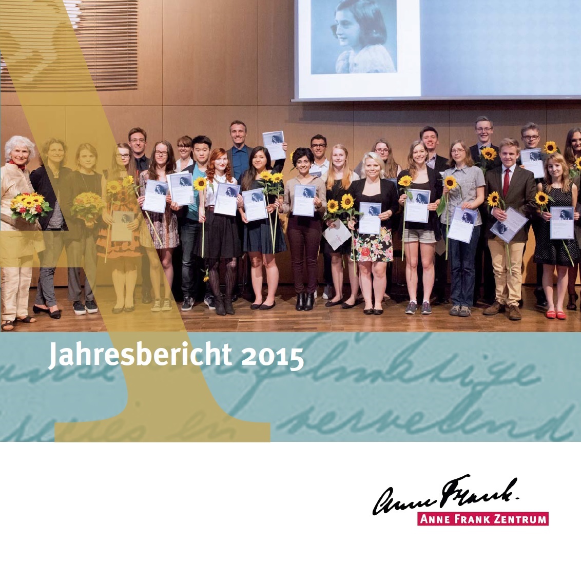 Auf dem Bild sieht man eine Gruppe von meist jungen Menschen, die für ein Gruppenfoto posieren. Die jungen Menschen halten alle eine Urkunde und eine Blume in der Hand. Im Hintergrund ist ein Bild von Anne Frank auf eine Leinwand projiziert. Darunter steht Jahresbericht 2015 des Anne Frank Zentrums.