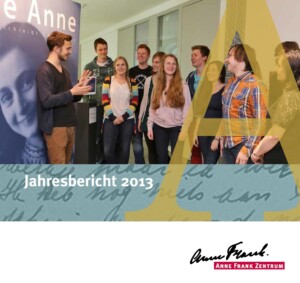 Auf dem Bild steht eine Gruppe von Menschen, die vor einem anderen Menschen steht, der ihnen etwas erklärt. Er selber steht vor einem Plakat, auf dem Anne Frank drauf ist. Darunter steht Jahresbericht 2013