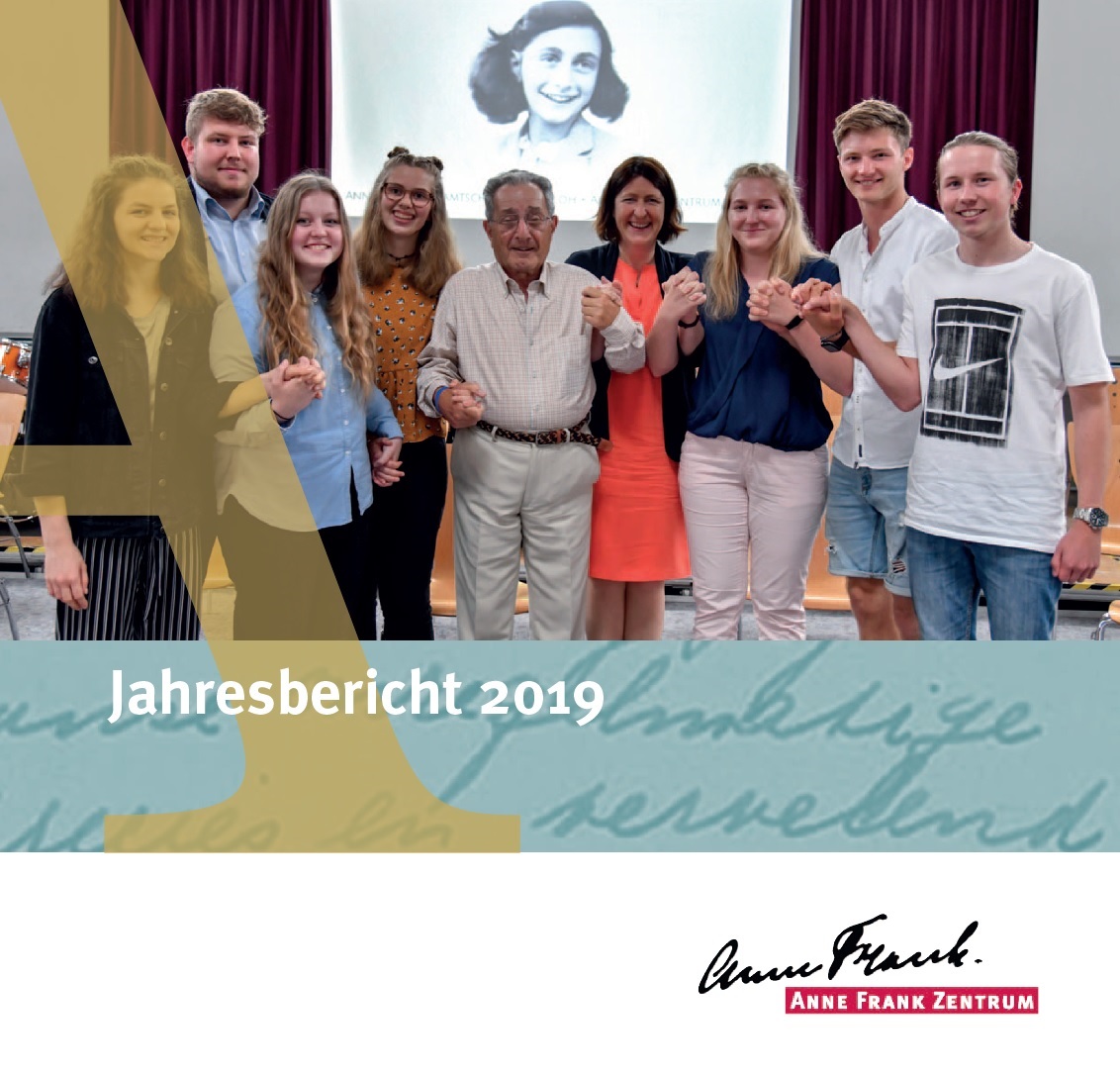 Auf dem Bild sieht man Menschen die für ein Gruppenfotoposieren und sich dabei an den Händen halten. Im Hintergrund ist ein Bild von Anne Frank auf eine Leinwand projiziert. Darunter steht Jahresbericht 2019 des Anne Frank Zentrums.