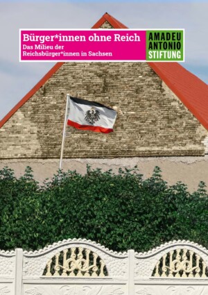 Auf dem Bild ist im Hintergrund ein Teil eines Hauses zu sehen. Davor ist eine Flagge des deutschen Kaiserreiches gehisst, davor sieht man eine Buschhecke, die wiederum hinter einer verzierten Grundstücksmauer steht. Oben auf dem Bild steht Bürger*innen ohne Reich. Das Milieu der Reichsbürer*innen in Sachsen